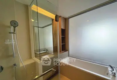Modern bathroom with glass shower and bathtub in luxury apartment