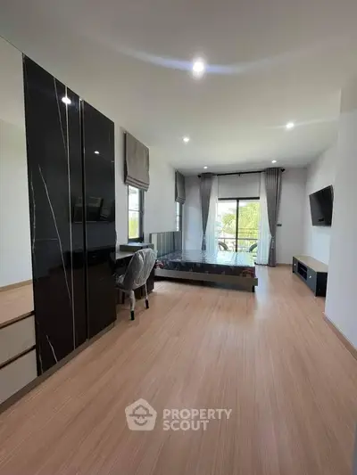 Spacious modern bedroom with large windows and sleek furnishings