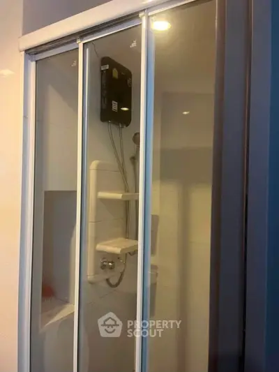 Modern bathroom shower with sliding glass doors and built-in shelves