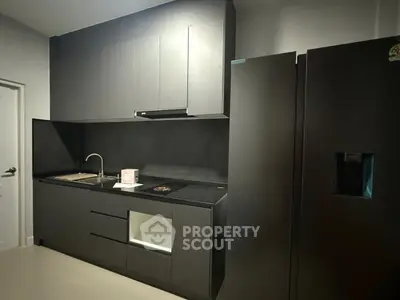 Modern kitchen with sleek black cabinetry and built-in appliances