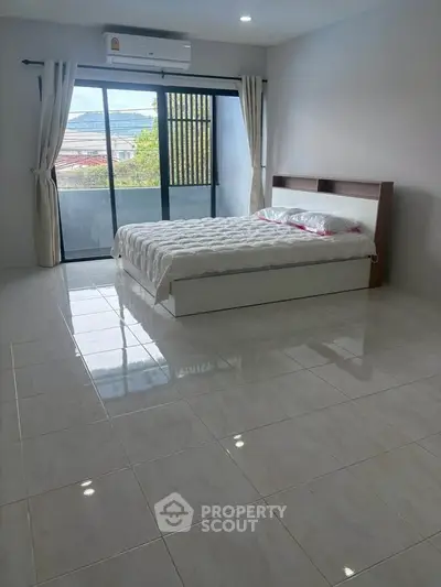 Spacious bedroom with large windows and scenic view, perfect for relaxation and comfort.