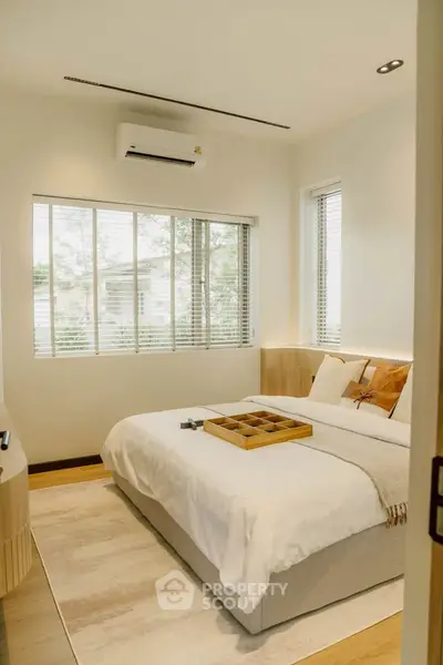 Cozy modern bedroom with large window and stylish decor