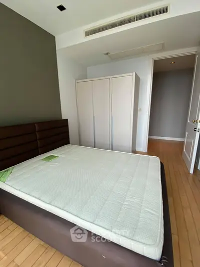 Spacious bedroom with modern design and ample natural light, featuring a comfortable bed and sleek wardrobe.