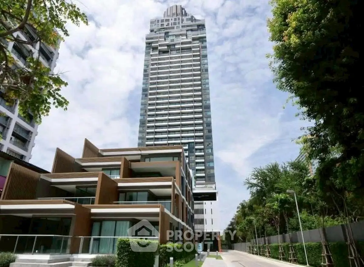 Stunning modern high-rise building with lush greenery and clear sky view.