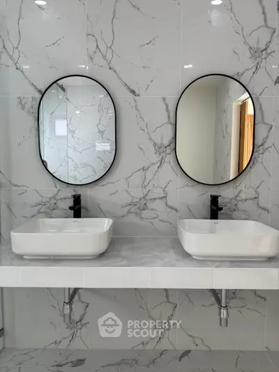 Elegant bathroom with dual sinks and marble wall tiles
