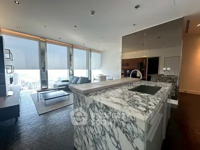 Luxurious modern living room with marble kitchen island and panoramic city views.