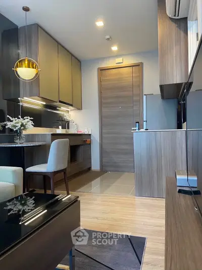 Modern kitchen and dining area with sleek cabinetry and elegant lighting in a stylish apartment.