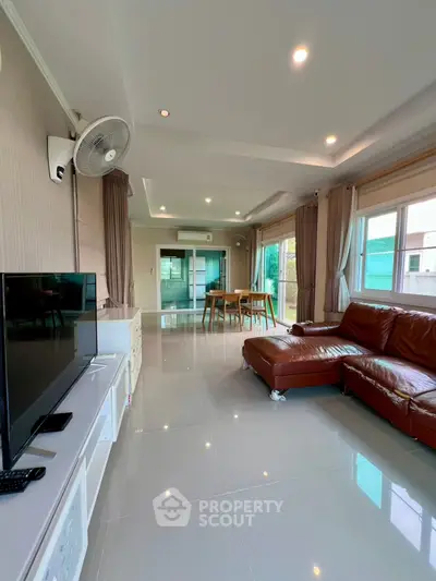 Spacious living room with modern decor and large windows for natural light