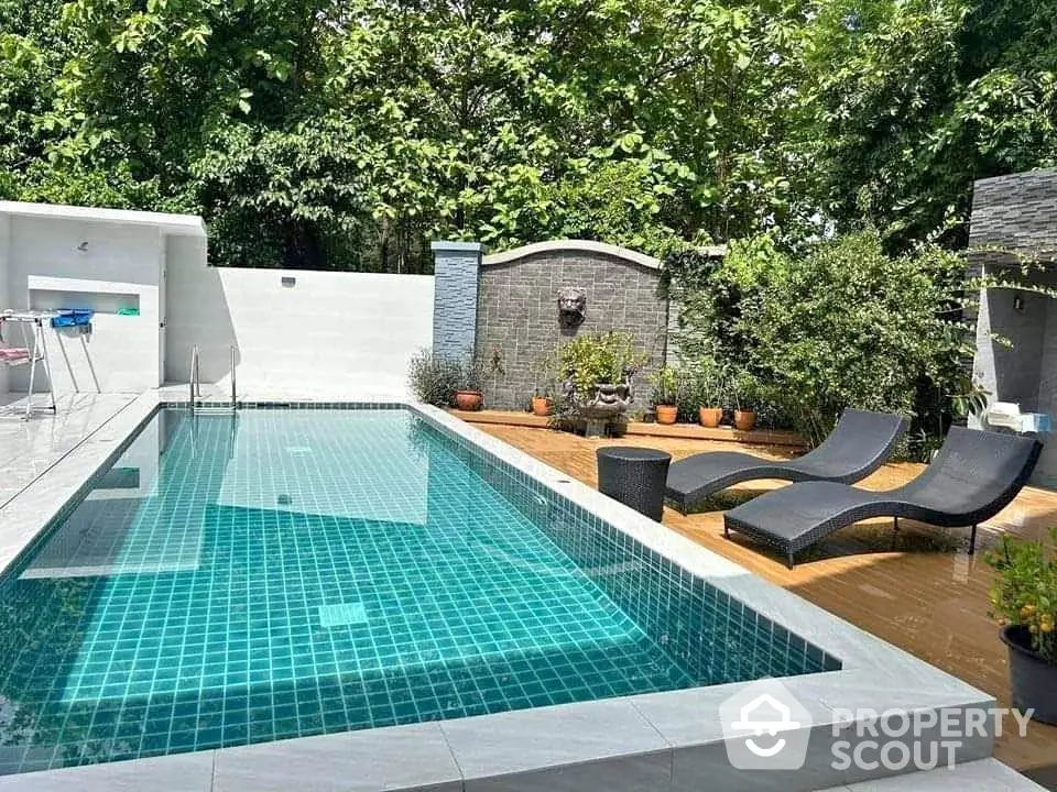 Luxurious outdoor pool area with modern lounge chairs and lush greenery