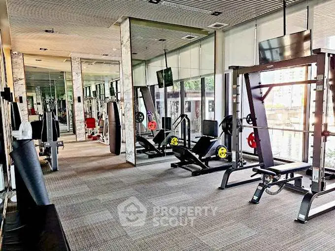 Modern gym with state-of-the-art equipment and mirrored walls in luxury building.