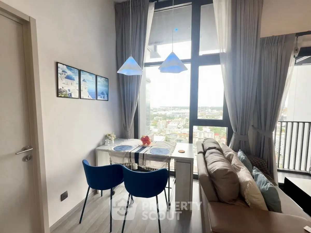 Modern living room with large windows and city view, featuring stylish furniture and elegant decor.
