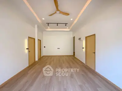 Spacious modern living room with wooden flooring and ceiling fan