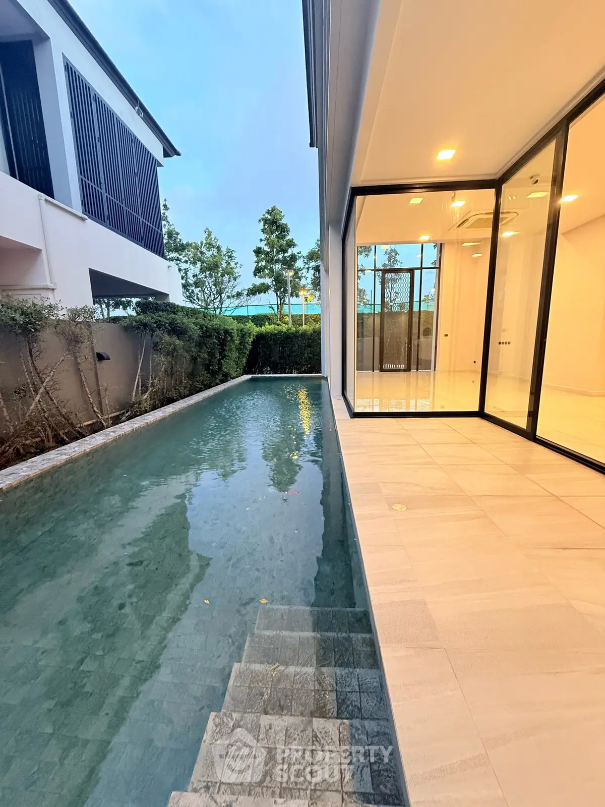 Luxurious modern home with private pool and elegant glass doors, perfect for serene living.