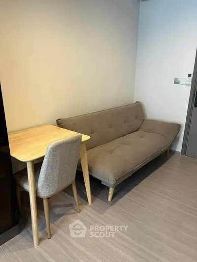 Cozy living room with modern sofa and wooden dining set, perfect for urban living.