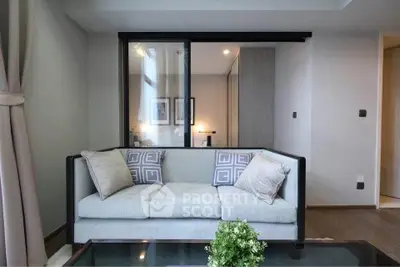 Modern living room with stylish sofa and glass partition in a contemporary apartment.
