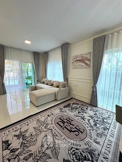 Elegant living room with modern decor, large windows, and stylish rug in a bright, inviting space.