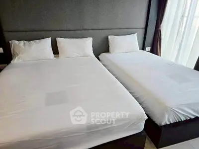 Spacious bedroom with two comfortable beds and elegant decor, perfect for relaxation and restful sleep.