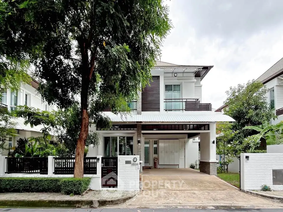 Elegant modern house with spacious driveway and lush greenery in a serene neighborhood.