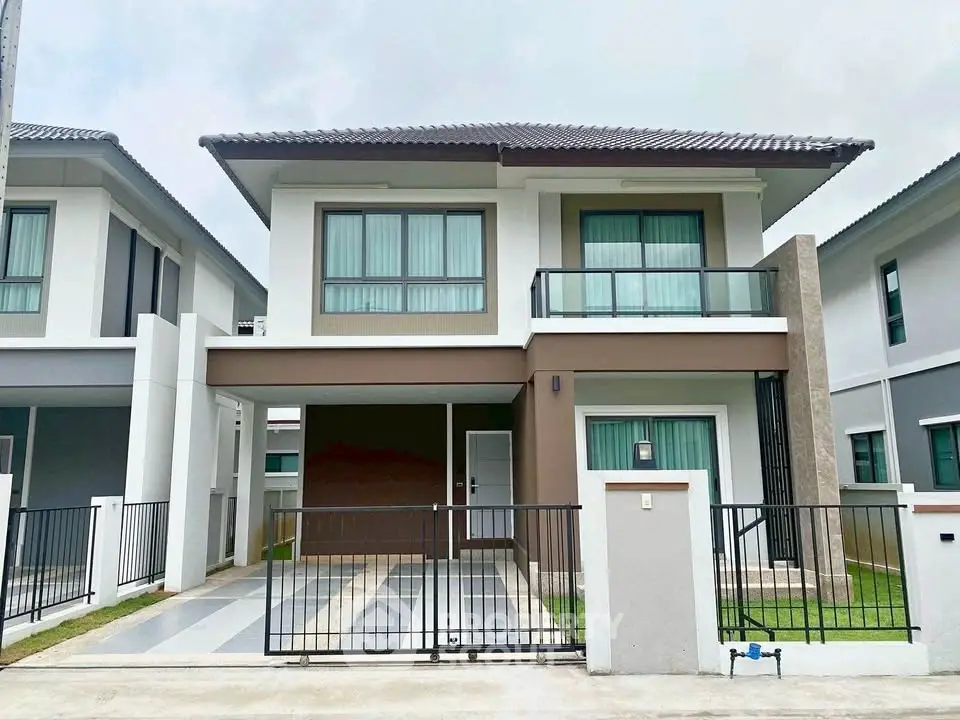 Modern two-story house with sleek design and spacious driveway in a suburban neighborhood.