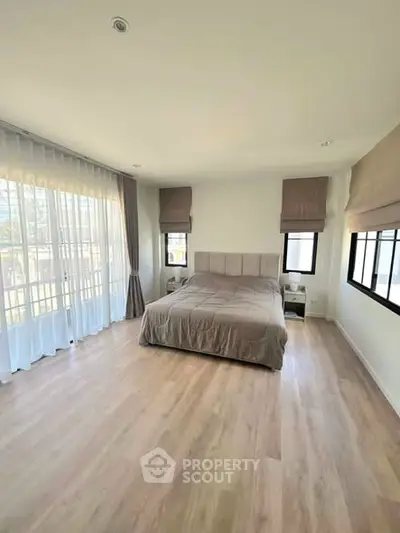 Spacious bedroom with large windows and elegant decor