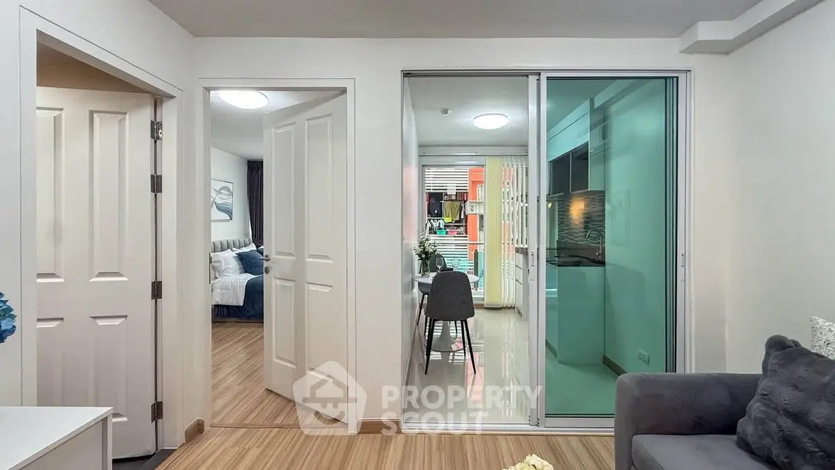 Modern apartment interior with sliding glass doors, cozy living area, and stylish dining space.