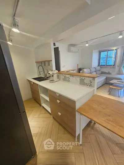 Modern open-layout kitchen with sleek design and cozy living area, perfect for urban living.