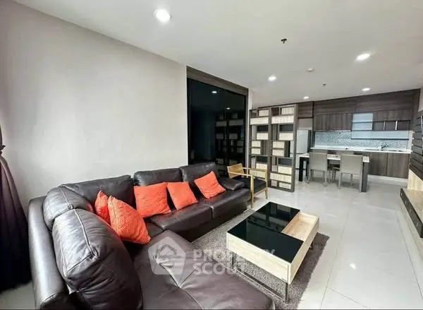 Modern living room with leather sofa and open kitchen layout