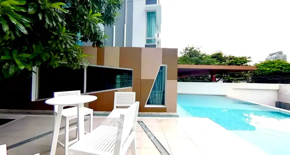 Modern poolside area with stylish seating and lush greenery in a luxury property.