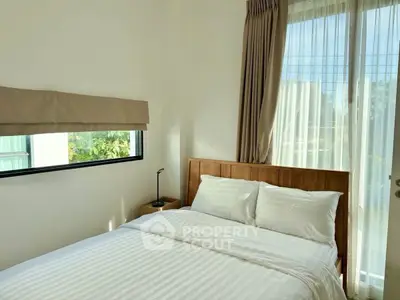 Cozy bedroom with natural light and modern decor, featuring a comfortable bed and stylish window treatments.