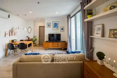 Modern living room with stylish decor and open layout, featuring a cozy sofa and elegant dining area.