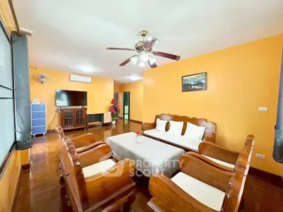 Spacious living room with wooden furniture and bright walls, perfect for family gatherings.