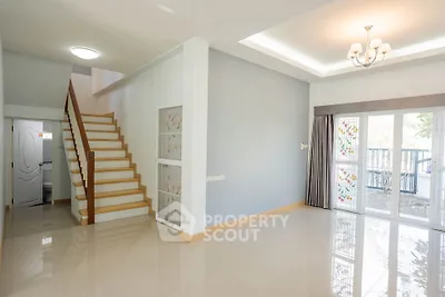 Spacious modern living room with elegant staircase and large windows