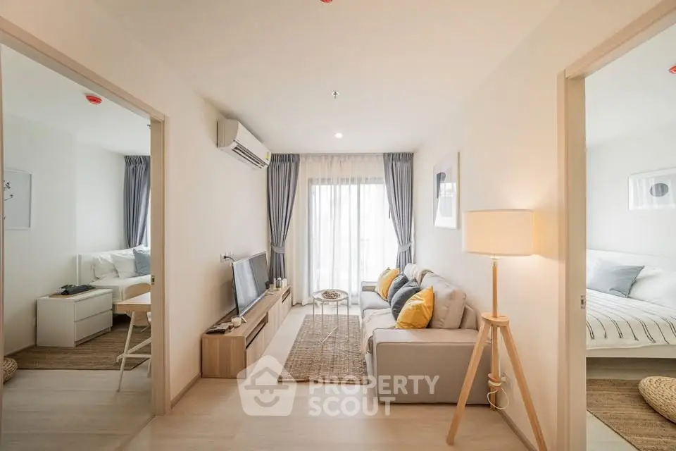 Modern living room with cozy decor and natural light in a stylish apartment.