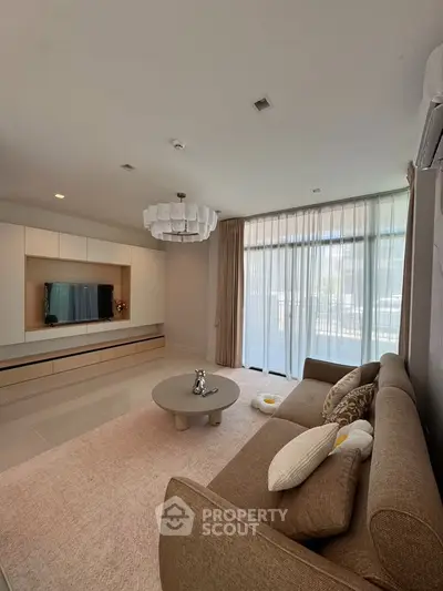 Spacious modern living room with elegant decor and large windows for natural light.