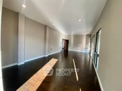 Spacious empty living room with hardwood floors and large windows