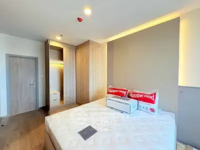 Modern bedroom with wooden flooring and built-in wardrobe, featuring a cozy bed and stylish decor.