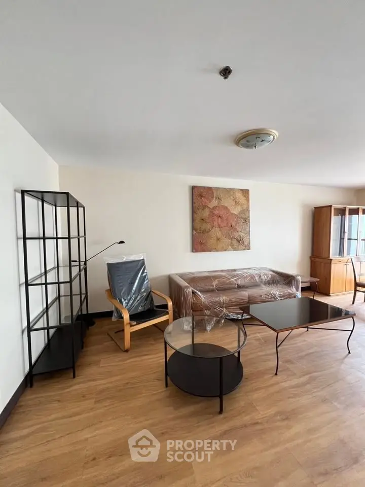 Spacious living room with modern furniture and wooden flooring in a stylish apartment.