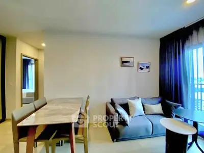 Modern living room with cozy sofa and dining area in open layout apartment.