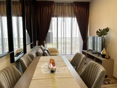 Elegant living room with dining area, modern decor, and large windows offering natural light.