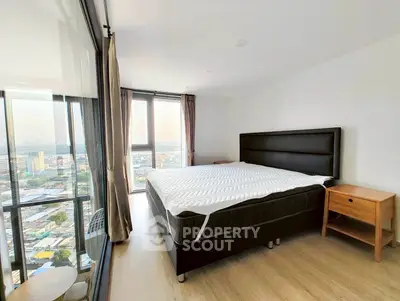 Spacious bedroom with panoramic city view in modern high-rise apartment
