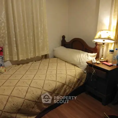 Cozy bedroom with elegant wooden bed and warm lighting, perfect for relaxation.