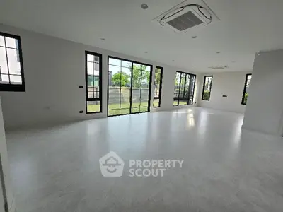 Spacious empty living room with large windows and garden view