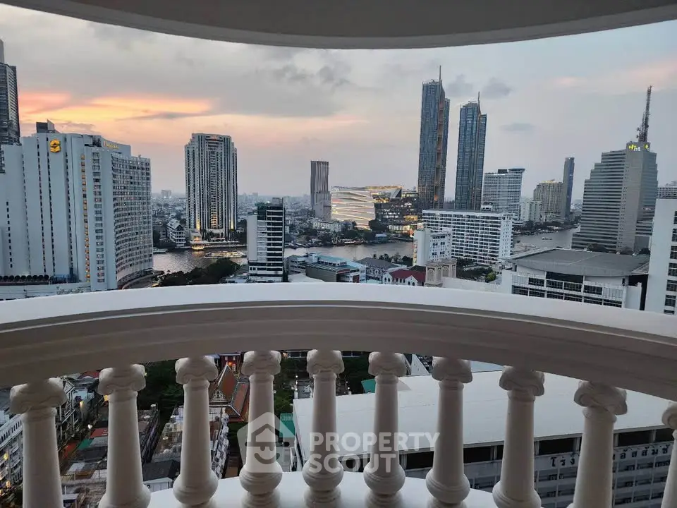 Stunning cityscape view from a high-rise balcony at sunset, showcasing modern skyscrapers and a serene river.