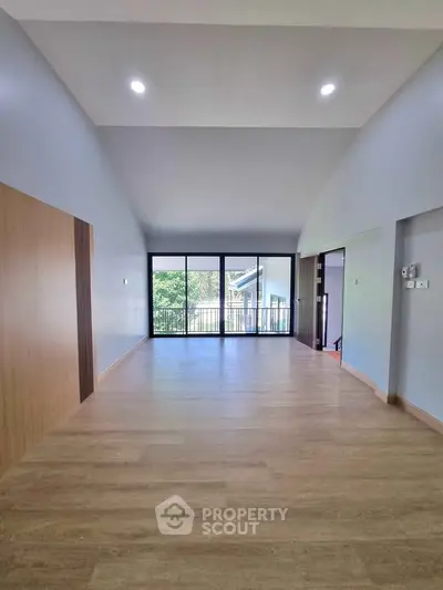 Spacious modern living room with large windows and wooden flooring