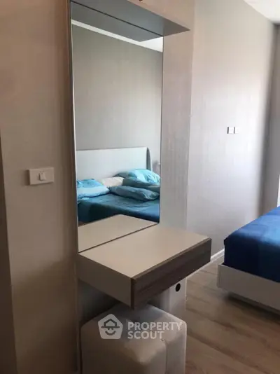 Modern bedroom with stylish vanity and comfortable bed in a cozy apartment.