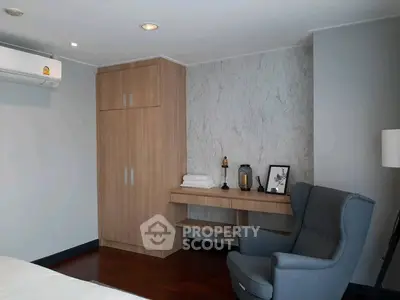 Modern bedroom with stylish armchair and wooden wardrobe, perfect for cozy living.