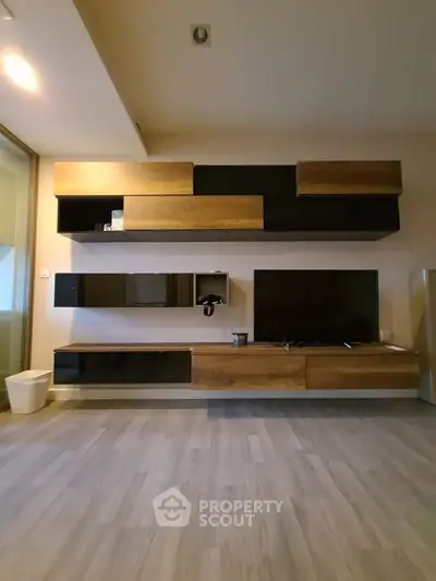Modern living room with stylish wooden wall-mounted cabinets and sleek flooring.
