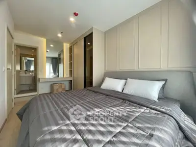 Modern bedroom with stylish decor and ensuite bathroom in a contemporary apartment.
