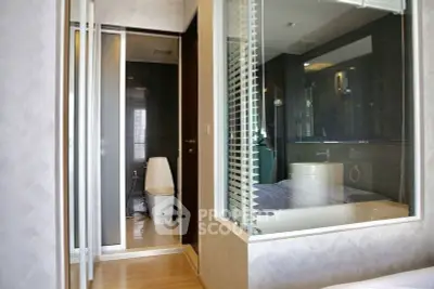 Modern bathroom with glass partition and sleek design in a contemporary apartment.