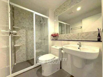 Modern bathroom with glass shower and sleek fixtures in a contemporary apartment.
